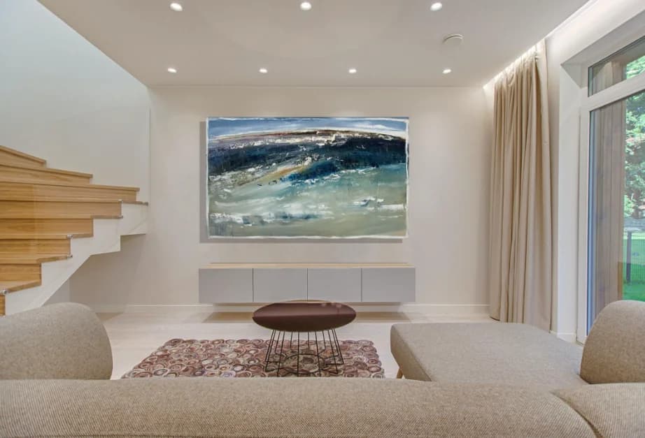 The Wild Sea: stormy blue-green abstract wave painting in minimalist cream living room. Original painting by Kim Kennedy.